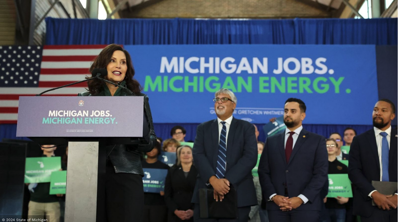 Photo of woman standing at podium with sign behind her that reads "Michigan Jobs. Michigan Energy."